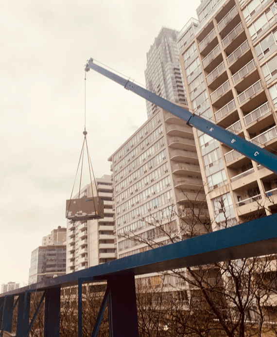 A Crane lifts a 10 TON York Commercial HVAC rooftop unit on to a building in Midtown Toronto 