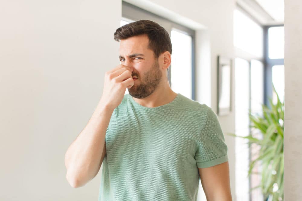 A Man Plugging His Nose Because of Bad Smelling HVAC